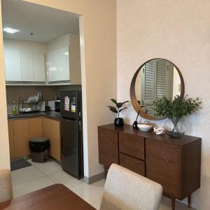 a kitchen with a table and a mirror on a dresser at Elegant 1BR with Great View, Panoramic Pool Near Ortigas CBD - 24 in Manila