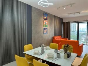 a dining room with a table and yellow chairs at NEW 4Queen Bed 3 Room 2CP near Gurney with tvbox and KTV Set in Tanjong Tokong