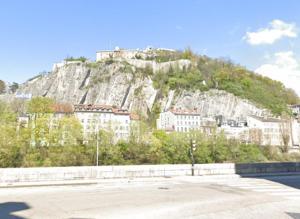 a mountain with a town on top of it at Suite Vinicole Hypercentre, Bastille & Gare 9 min à pied in Grenoble