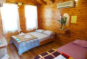 a bedroom with a bed in a log cabin at Sheriff, Olympos in Kumluca
