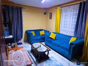 a living room with a blue couch and yellow pillows at Memz B&B in Nairobi