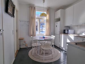 a small kitchen with a table and chairs in it at Pispalan Helmi - Koti Näköalalla in Tampere +9 photos
