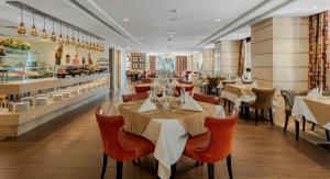 a restaurant with tables and chairs and a buffet at Sofitel Shahd Al Madinah in Medina