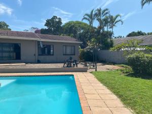 a swimming pool in the backyard of a house at Tranquil Coastal Home with Pool Family-Friendly Stay in Uvongo Beach