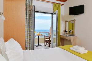 a bedroom with a bed and a view of the ocean at Pharos Rooms in Ilia