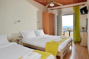 伊利雅Pharos Rooms的一间带两张床的卧室,可欣赏海景