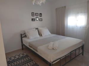 a bedroom with a bed with two slippers on it at Roni's Place in Nea Kallikrateia
