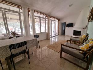 a living room with a table and chairs and a fireplace at Roni's Place in Nea Kallikrateia