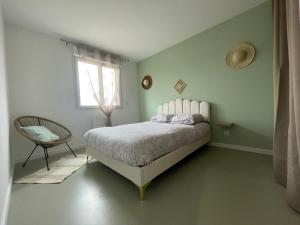 a bedroom with a bed and a chair and a window at Les jumelles in Saint-Gaudens