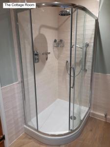 a shower with a glass door in a bathroom at Cotswold Cottage B&B - 5 Minutes Walk to Village Pub in Luckington