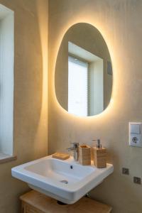 a bathroom with a white sink and a mirror at Boutique Apartment in Freising, nahe München und Flughafen München in Freising