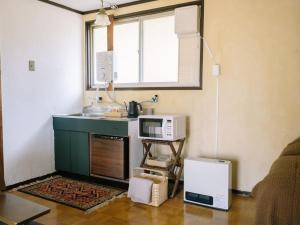 a kitchen with a sink and a microwave at お宿のごえん in Shijonawate