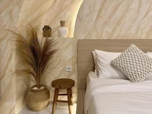 ヌサドゥアにあるSpring Villa Nusa Duaのベッドルーム1室(ベッド1台、植物のあるテーブル付)