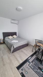 GiurgiuStudio cu o camera的一间卧室配有一张床、一张桌子和一张地毯。