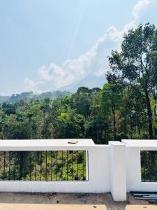 a white balcony with a view of the mountains at AYD-IN BY GREENLEAVES Resort in Vythiri