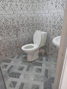 a bathroom with a toilet and a sink at Sun City Family Inn in Hatton