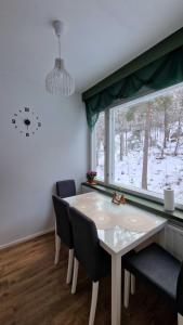 a dining room with a table and chairs and a window at Rentoudu Tässä in Lahti +9 photos