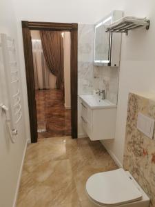 Un baño con inodoro, lavabo y espejo. en Beach Lounge Luxory Apartments, en Melnragė