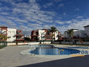 ein Schwimmbad vor einigen Wohnhäusern in der Unterkunft Chalet El Coto Vera Playa, Tres dormitorios, Urbanización Piscina, Terraza, Sótano, Garaje in Vera