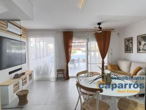 ein Wohnzimmer mit Tisch und Couch in der Unterkunft Chalet El Coto Vera Playa, Tres dormitorios, Urbanización Piscina, Terraza, Sótano, Garaje in Vera