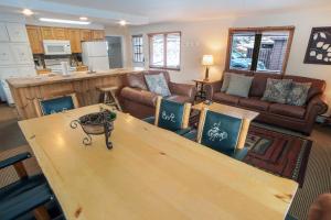 a living room with a large wooden table with chairs at Timber Creek Chalets- 14 chalet in Estes Park