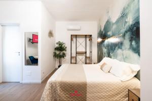 una camera da letto con un letto e un quadro sul muro di BARIROOMS - Melo Suites a Bari