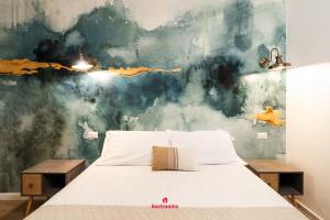 una camera da letto con un letto e un dipinto sul muro di BARIROOMS - Melo Suites a Bari