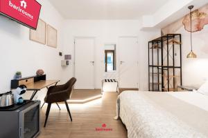 una camera da letto con un letto, una scrivania e una TV di BARIROOMS - Melo Suites a Bari Altre 40 foto