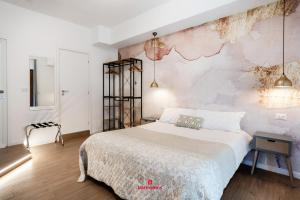 una camera con un grande letto e una parete con un murale di BARIROOMS - Melo Suites a Bari