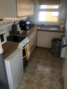una cocina con fregadero y estufa horno superior en 2 Bedroom Chalet Close to Beach, en Hemsby