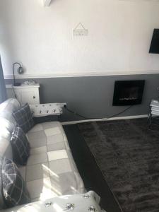 Una sala de estar con un sofá y una chimenea. en 2 Bedroom Chalet Close to Beach, en Hemsby