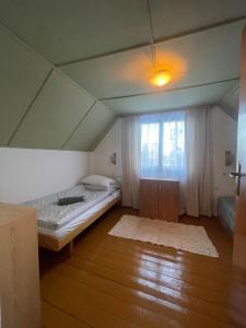 a small room with a bed and a window at Chata Jelka in Tatranska Strba