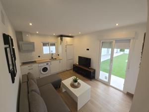 a living room with a couch and a table and a kitchen at Chiclanafactory in Chiclana de la Frontera