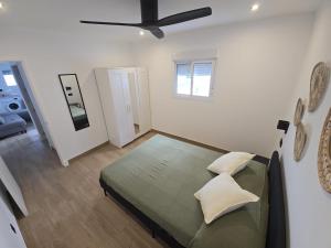 a bedroom with a bed and a ceiling fan at Chiclanafactory in Chiclana de la Frontera
