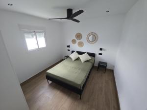 a white bedroom with a bed and a window at Chiclanafactory in Chiclana de la Frontera +2 photos
