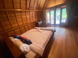 a bedroom with two beds in a room with windows at Sri Sedana Homestay in Sidemen