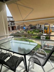 una mesa de cristal y 2 sillas en un balcón con vistas en Dionysus building, en Ofrinion
