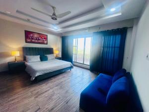 a bedroom with a bed and a blue couch at Executive appartment in bahria hieghts 1 in Rawalpindi