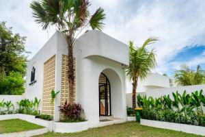 a white church with palm trees in front of it at Tamanna Villa Uluwatu in Uluwatu