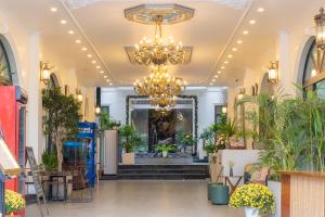 a lobby with a chandelier and potted plants at Roza Luxury Hotel Cat Ba - Pool & Rooftop in Cat Ba +160 photos