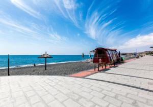 a view of a beach with an umbrella and the ocean at Villa Garden in Tarajalejo +13 photos
