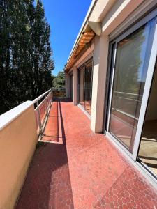 a balcony of a house with a red tile walkway at Flower spa - Jacuzzi intérieur - T2 in Toulouse
