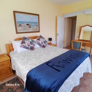 Un dormitorio con una cama con una manta azul encima. en ROMANZA APARTMeNT, en De Kelders