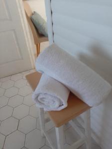 ランバーツ・ベイにあるCoCo de Mer - Self Catering Log 2のバスルームのスツールにタオルを積み重ねます。 +10枚の写真