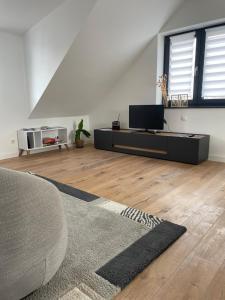 a living room with a couch and a tv at Wohnung mit großer Dachterrasse in Aachen