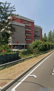 un edificio rojo al lado de una carretera en Casa Linabelli Reggio Emilia, en Reggio Emilia