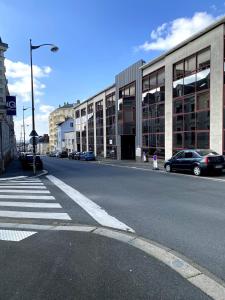 an empty street with cars parked in front of a building at L'Estrade, Studio centre-ville in Cholet
