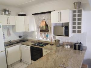 a kitchen with white cabinets and a counter top at 76 Eden Dunes Beachfront Apartment - Shelly Beach in Margate