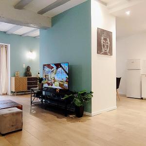 a living room with a flat screen tv on a wall at Casa Luna - Une Maison à la Situation Exceptionnelle Offrant Sérénité et Confort en Plein Cœur de Bourges in Bourges