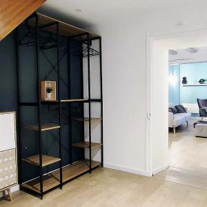 a black book shelf in a living room at Casa Luna - Une Maison à la Situation Exceptionnelle Offrant Sérénité et Confort en Plein Cœur de Bourges in Bourges